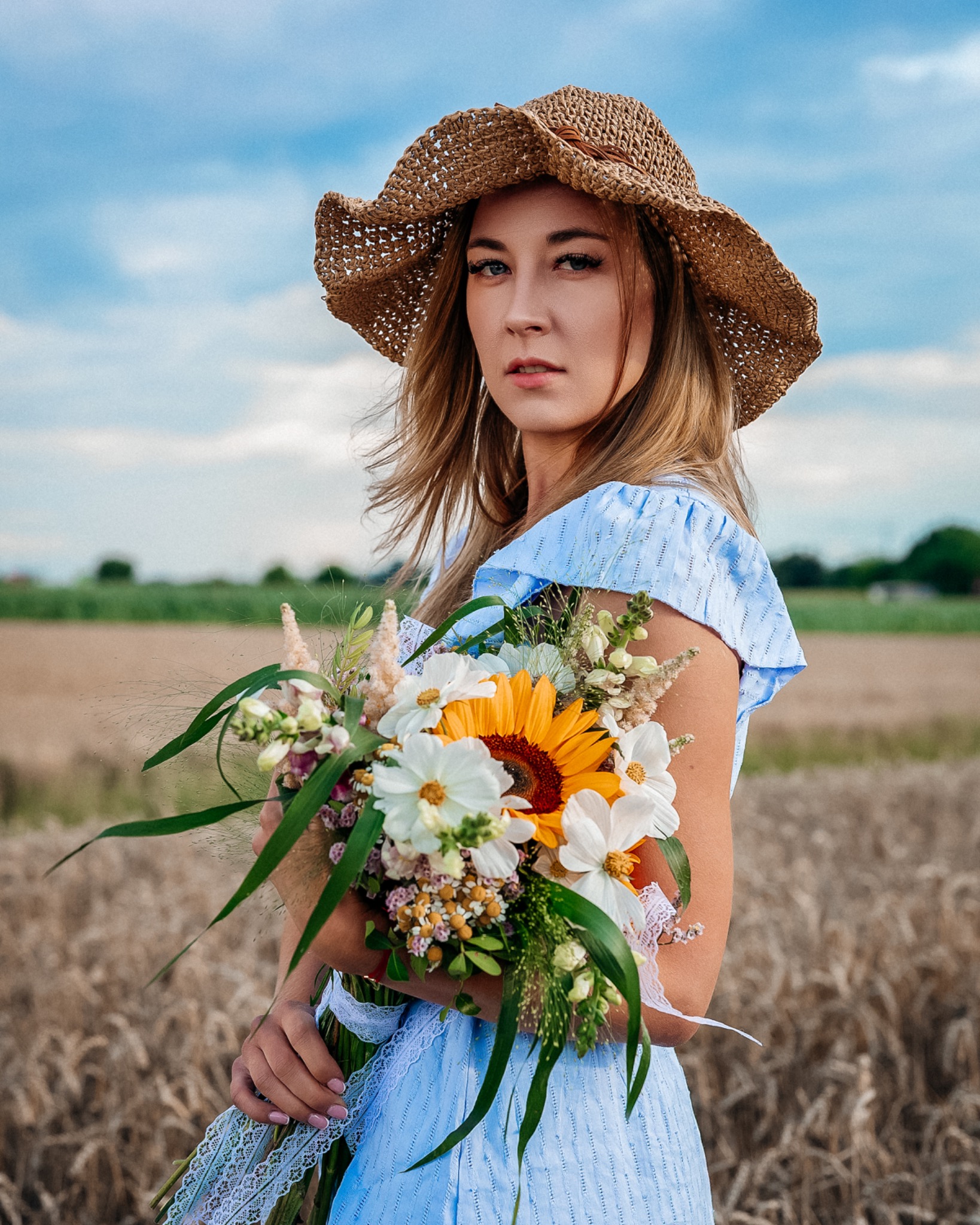 Kobieca sesja boho w niebieskiej sukience z bukietem