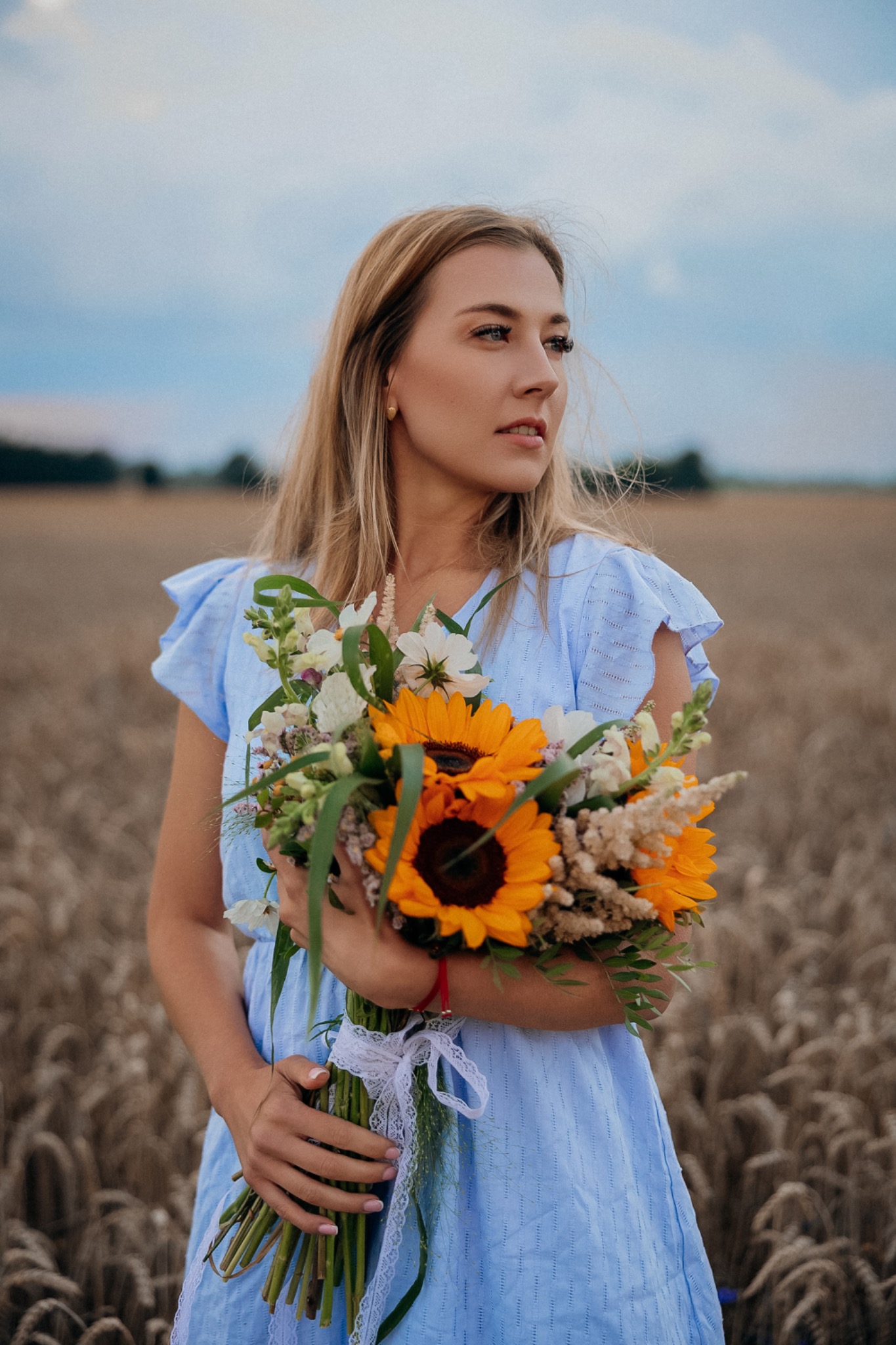 Kobiecy portret plenerowy z bukietem polnych kwiatów