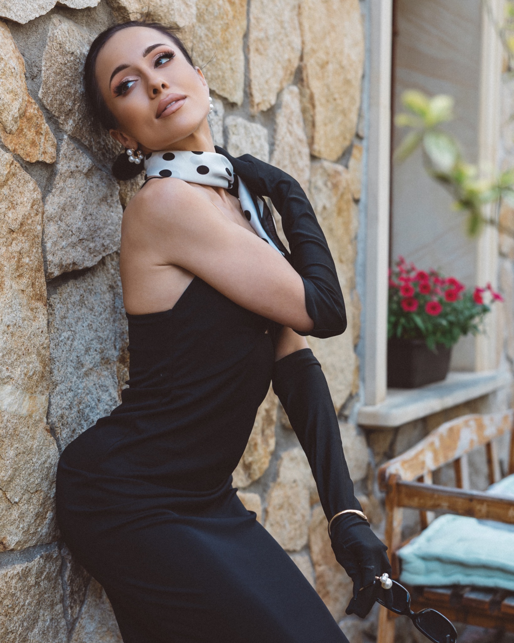 Elegancki kobiecy portret w czarnej sukience przy murze