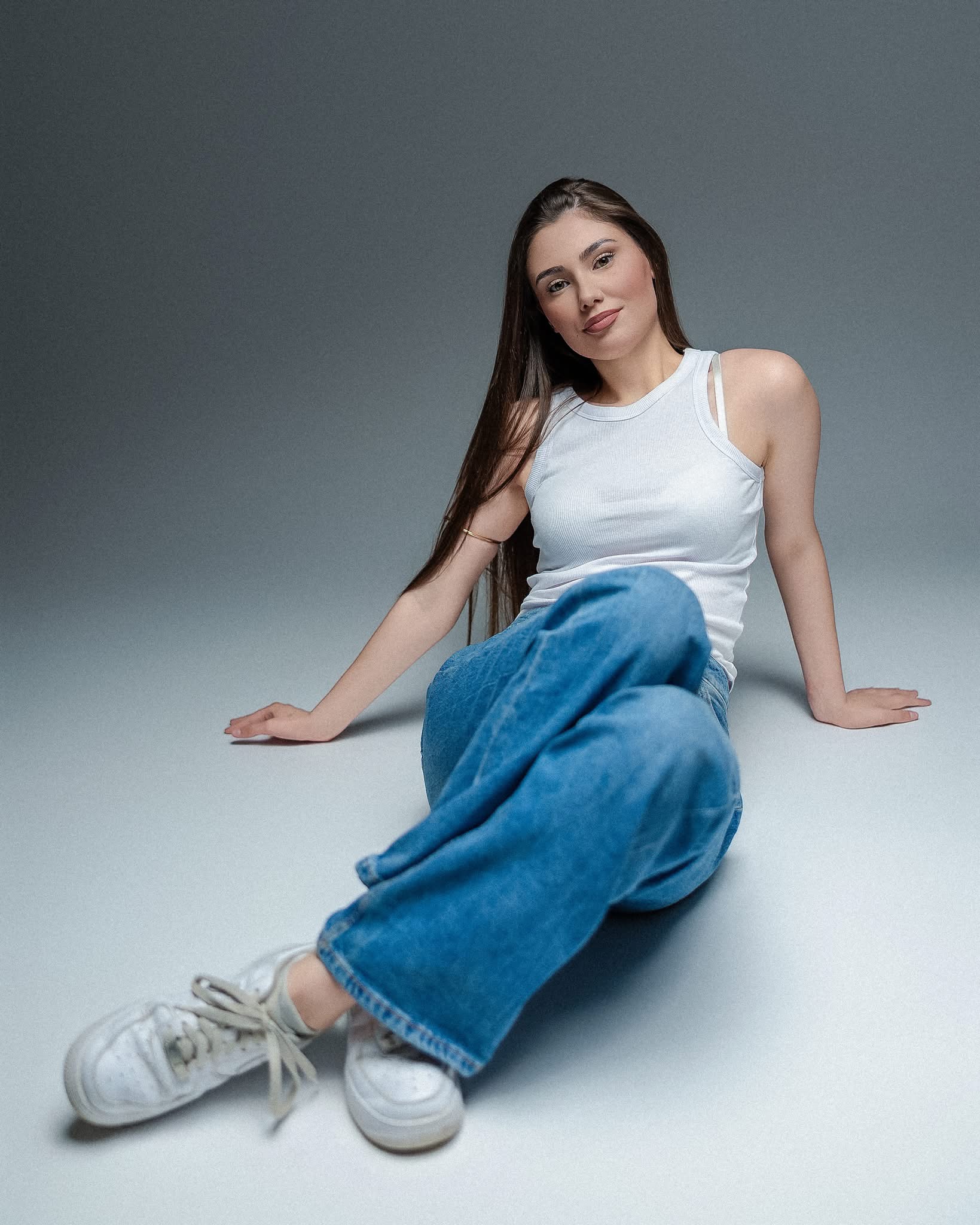 Swobodny kobiecy portret w białym topie i jeansach